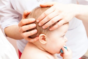 A baby being examined for skull fractures