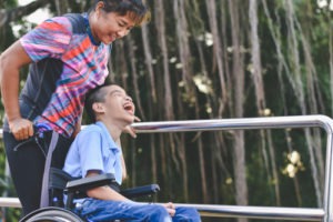 A child with erbs palsy in a wheelchair at a park