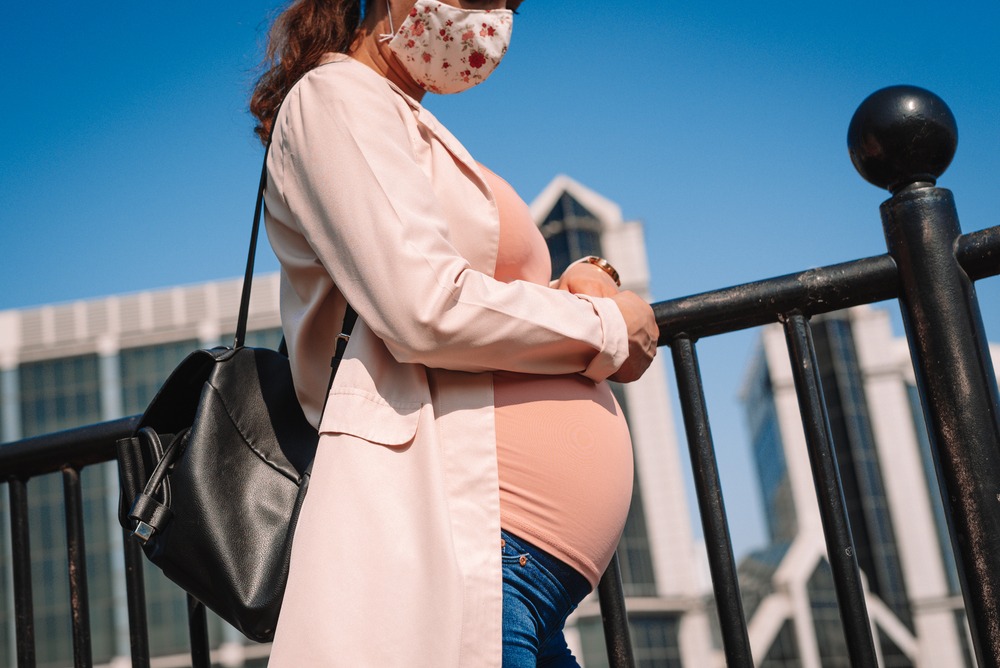 a pregnant woman wearing a mask