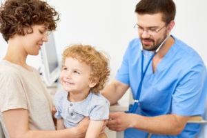 A parent holding a child while a doctor does an examination