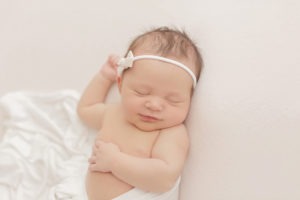 baby girl sleeping with bow in her hair