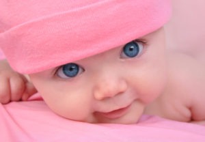 baby with pink blanket on head