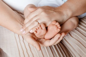 mom’s hand holding baby feet
