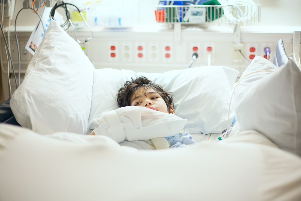 A child with cerebral palsy lies in a hospital bed.