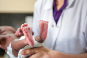 Female pediatrician holding a newborn