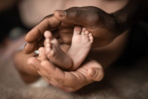 black mom holding baby feet