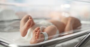 A baby with a birth injury sleeps in a hospital bed. A cerebral palsy lawyer in Kansas can help birth injury victims and their families seek justice.