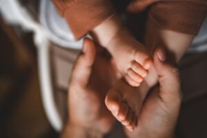 A cerebral palsy lawyer in North Carolina holds the feet of a baby diagnosed with cerebral palsy.