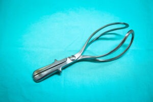 A forceps used for delivery sits on a table. If your newborn experienced a birth injury caused by forceps delivery complications, a birth injury lawyer can hold the at-fault party accountable.