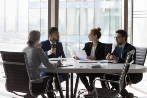 A birth injury lawyer sitting with his client and negotiating with an insurance adjuster in a conference room.