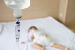 Baby boy sleeping on the bed with an infusion set. What is infant meningitis?