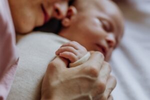 A mother hugging an infant. Learn about the average settlement for a newborn brain hemorrhage.