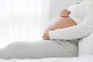 Woman holding her pregnant belly. Find out how long a baby can survive after a placental abruption.