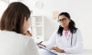 A gynecologist discussing the risk of harm related to cholestasis with a patient.
